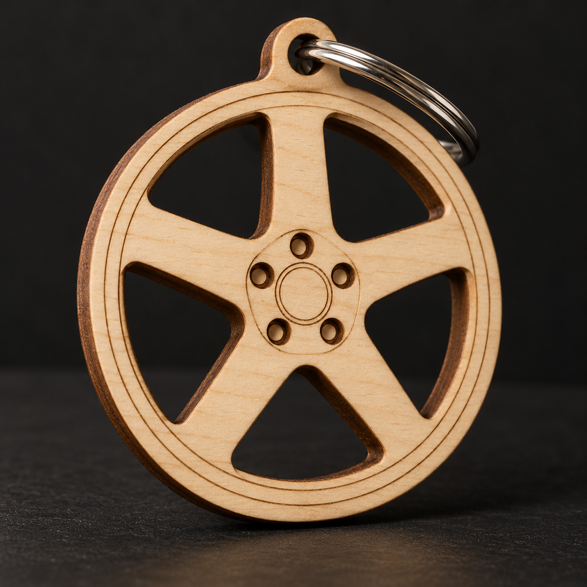 Five-spoke Birch Ply wheel key fob with actual open cutouts between connected spokes; illustrative rendering